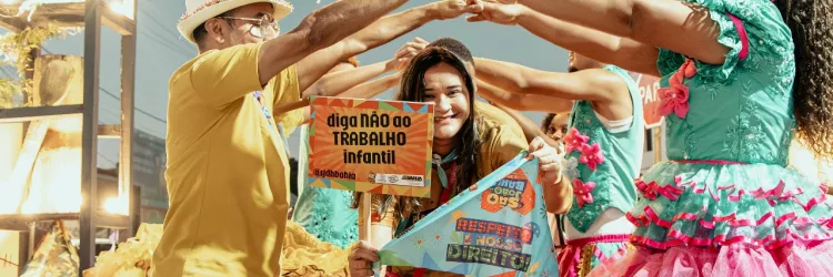 Uma mulher segura a placara com a frase "diga não ao trabalho infantil" na quadrilha junina