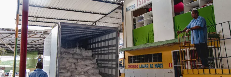 Pessoas descarregando do caminhão as doações na na Fundação Dr Jesus