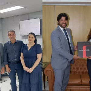 Imagem dividida em duas partes. À esquerda, três pessoas em um escritório iluminado: um homem de terno cinza e gravata azul, um homem de camisa xadrez azul escura e calça jeans, e uma mulher de vestido azul. Ao fundo, TV com gráficos e lousa branca. À direita, o mesmo homem de terno entrega um livro preto e vermelho com o título “INNOVARE” a uma mulher de camisa branca listrada e calça jeans.