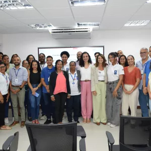 Foto coletiva dos participantes e palestrantes ao final do encontro. O grupo posa em frente à tela da apresentação, sorrindo. A imagem registra o encerramento da atividade do Janeiro Branco, destacando integração, participação e compromisso com a saúde mental.