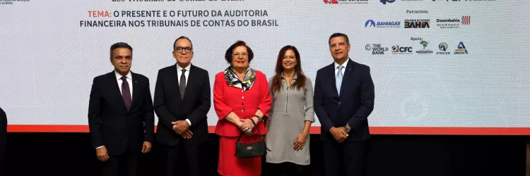 Grupo de cinco pessoas em trajes formais posando em frente ao painel do 3º Encontro Nacional de Auditoria Financeira dos Tribunais de Contas do Brasil (ENAF-TC).