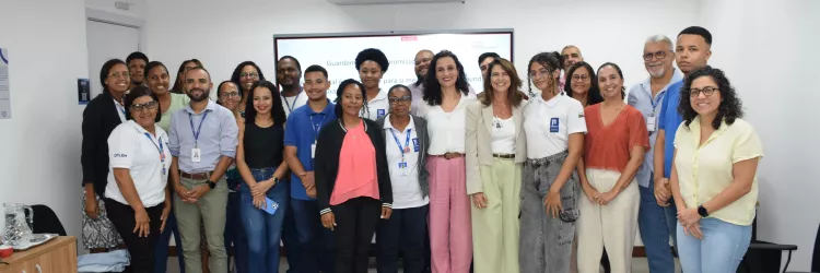 Foto coletiva dos participantes e palestrantes ao final do encontro. O grupo posa em frente à tela da apresentação, sorrindo. A imagem registra o encerramento da atividade do Janeiro Branco, destacando integração, participação e compromisso com a saúde mental.