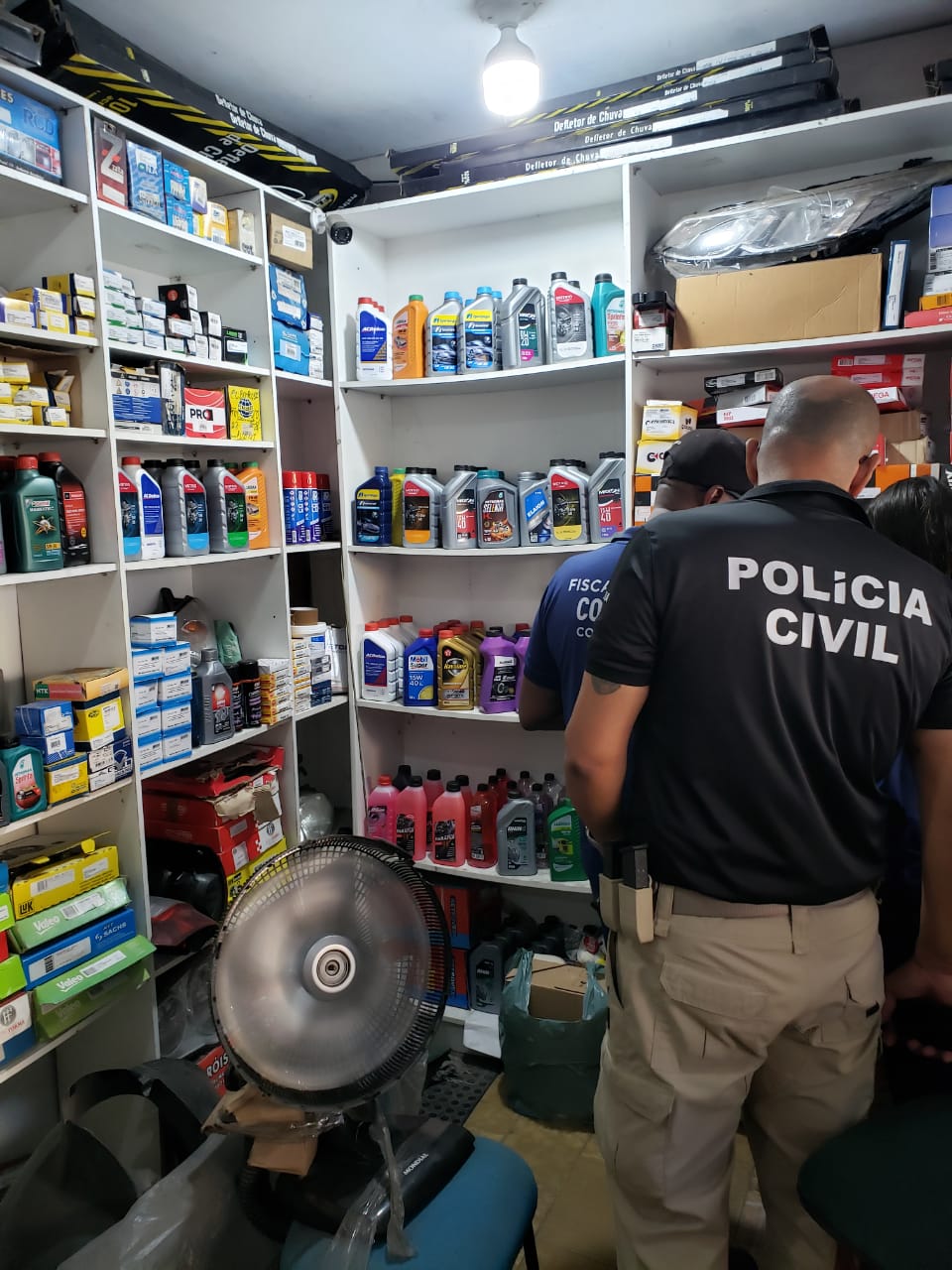 Policiais Civis vistoriando armazém de óleo automotivo