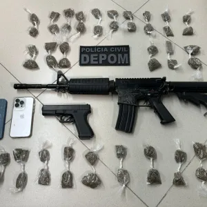 Fuzil, pistola, celulares e drogas apreendidas na delegacia.