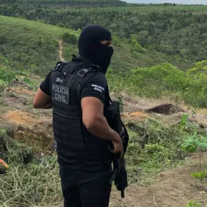 Policial de balaclava portando um fuzil
