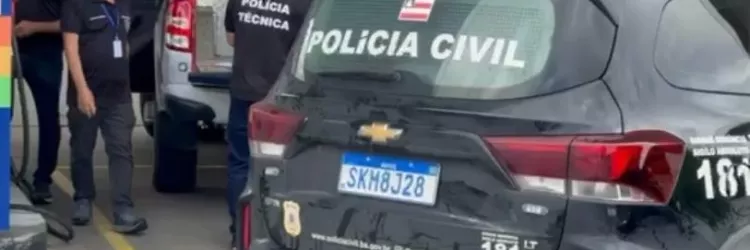 Viatura da Polícia Civil da Bahia estacionada em um posto, com agentes da Polícia Técnica ao fundo próximos a outra viatura, durante uma operação.