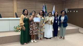 Camila Batista (Secretária da SPM), Luzitânia Silva (Formanda do curso), Helena Pataro (Diretora do CREASI), Iêda Santos (Coord. de Residência em Saúde da ESPBA), Liliane Mascarenha (Diretora da DGC/SESAB) e Trícia Calmpn (Superinte