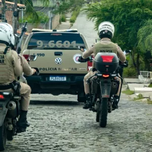 A imagem traz policiais de motocicletas e uma viatura a frente
