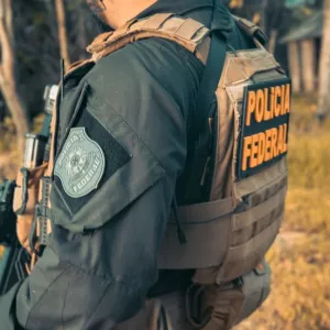 Um policial federal aparece segurando uma arma