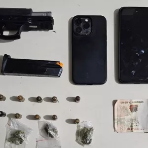 Arma e celualres apreendidos são exibidos