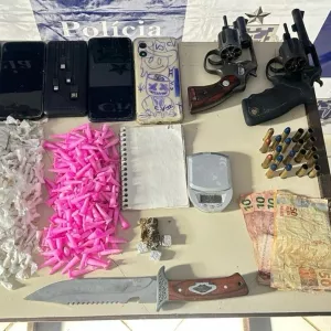 Armas e munições apreendidas estão sobre uma mesa