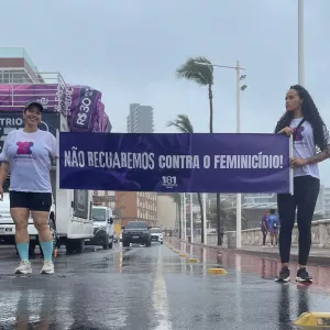 Duas mulheres seguram o cartaz da campanha