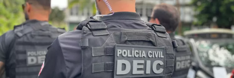 Um policial do DEIC está de costas em primeiro plano
