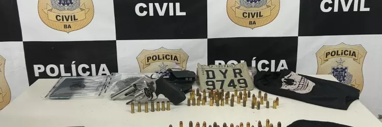 A imagem traz o material apreendido sobre uam mesa e o banner da Polícia Civil ao fundo