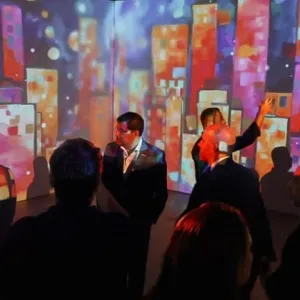 Pessoas diante de uma tela que projeta imagens coloridas