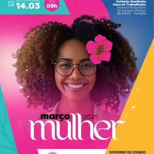 Mulher negra usando óculos com cabelo encaracolado enfeitado com uma flor rosa