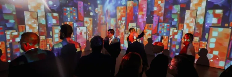 Pessoas diante de uma tela que projeta imagens coloridas