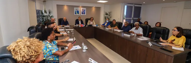 Conselheiros do Funtrad sentados à mesa de reunião